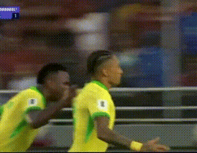 Two Soccer Players In Yellow And Green Jerseys Celebrating Goal GIF