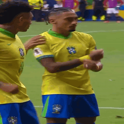 Two Soccer Players In Yellow Jerseys And Blue Shorts GIF
