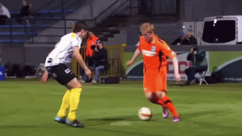 Two Soccer Players On A Field With Adzmci In The Corner GIF