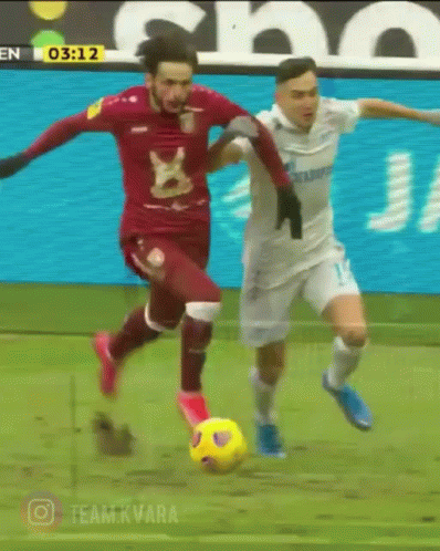 Two Soccer Players On A Field With The Time 03:12 In The Background GIF