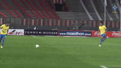 Two Soccer Players On Field With Tommy Hilfiger Ad GIF