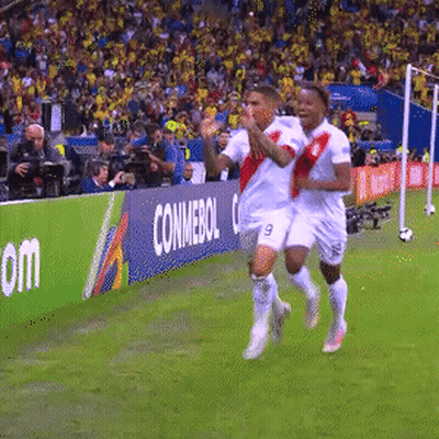 Two Soccer Players Running On A Field With A Conmebol Banner In The Background GIF