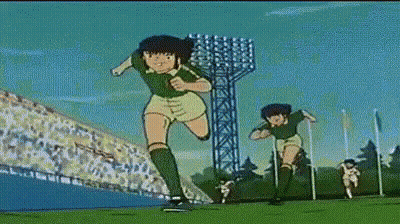 Two Soccer Players Running On Field With Crowd GIF