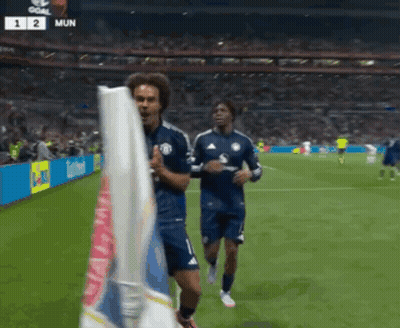 Two Soccer Players Running On Field With Scoreboard Saying Mun GIF