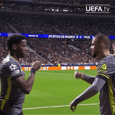 Two Soccer Players Shake Hands On A Field With Uefa.tv In The Upper Right Corner GIF