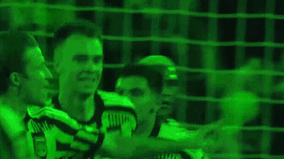 Two Soccer Players Standing In Front Of Green Background GIF