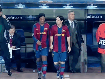 Two Soccer Players Walking Past Champions League Dugout GIF