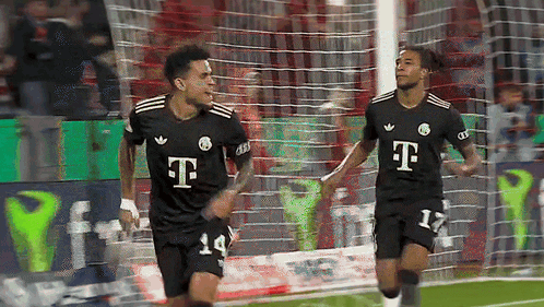 Two Soccer Players Wearing Black T-Mobile Jerseys Are Celebrating A Goal GIF
