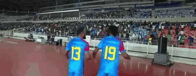 Two Soccer Players Wearing Blue Jerseys With The Number 13 And 19 On Them GIF