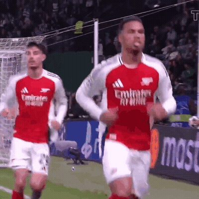 Two Soccer Players Wearing Emirates Airlines Jerseys Are Running On A Field GIF