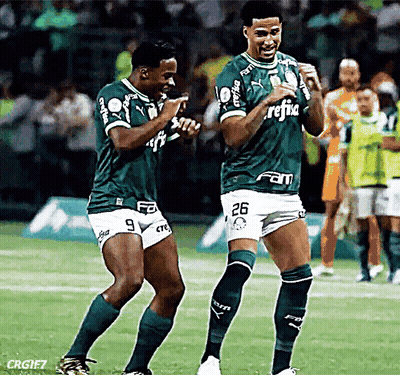 Two Soccer Players Wearing Green Jerseys With The Number 26 On The Shorts GIF