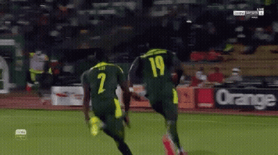 Two Soccer Players Wearing Jerseys With The Number 2 And 19 Running On A Field GIF