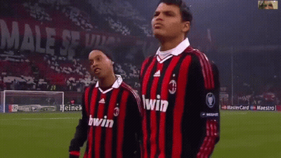 Two Soccer Players Wearing Red And Black Striped Jerseys With The Word Bwin On Them GIF