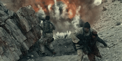 Two Soldiers Are Running In Front Of An Explosion In The Desert GIF