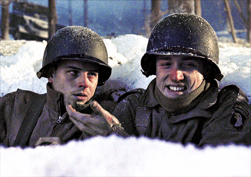 Two Soldiers Are Talking In The Snow And One Has A Patch On His Uniform That Says ' Army ' GIF