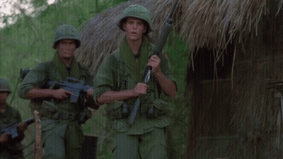 Two Soldiers In Front Of Thatched Hut With Explosion GIF