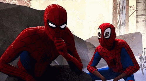 Two Spider-Man Are Sitting Next To Each Other On A Rock And Talking To Each Other . GIF