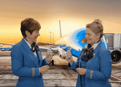 Two Stewardess Holding Small Houses By KLM Plane GIF
