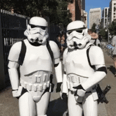 Two Stormtroopers Standing Next To Each Other On A Street GIF