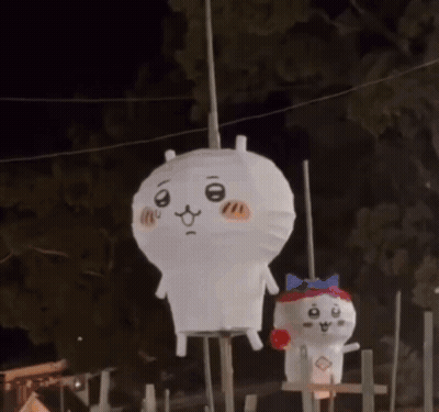 Two Stuffed Animals Are Hanging From A Rope In The Dark . GIF