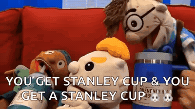 Two Stuffed Animals Are Sitting On A Couch And One Of Them Is Holding A Stanley Cup GIF