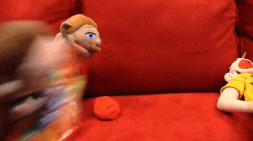 Two Stuffed Animals Are Sitting On A Red Couch And One Has Blue Eyes GIF