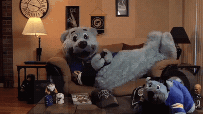 Two Stuffed Animals On Couch, One Wearing Blues Hat GIF