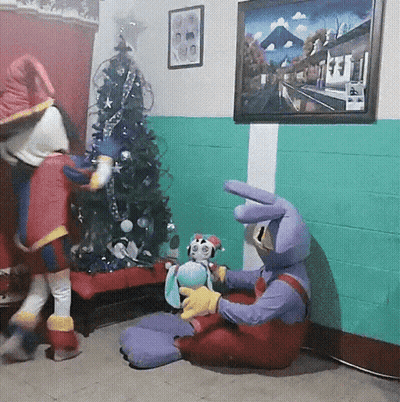 Two Stuffed Animals Sitting By Christmas Tree GIF
