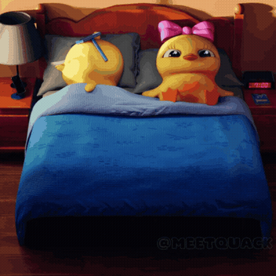 Two Stuffed Ducks on Bed with 7:00 Clock