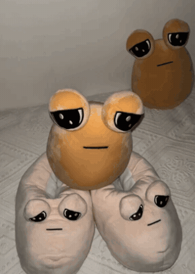 Two Stuffed Frogs Are Sitting On A Bed With Their Eyes Closed GIF