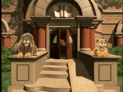 Two Stuffed Lions Are Sitting On The Steps Of A Building In Front Of A Building . GIF