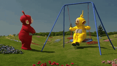 Two Teletubbies Are Swinging On A Swing Set In A Grassy Field GIF