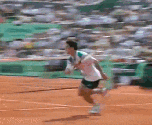 Two Tennis Players Are Playing On A Court With A Green Wall Behind Them That Says ' Lacoste ' GIF