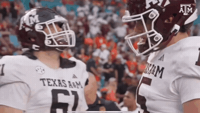 Two Texas A&M Football Players Talking On Field GIF