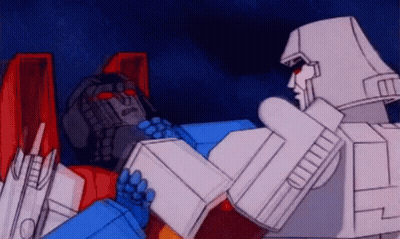 Two Transformers Standing Next To Each Other GIF