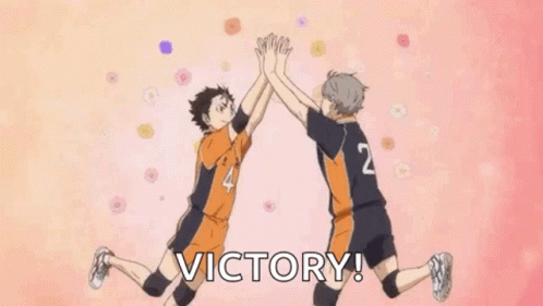 Two Volleyball Players Are Giving Each Other A High Five While Jumping In The Air . GIF
