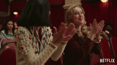 Two Women Are Clapping In A Theater With A Netflix Logo In The Corner GIF