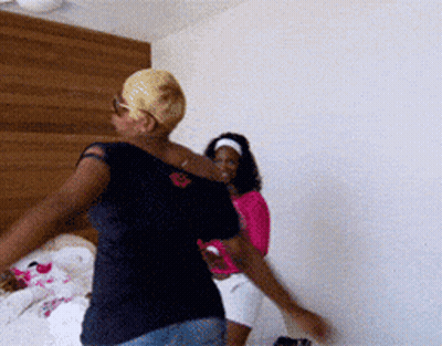 Two Women Are Dancing In A Bedroom With One Wearing A Pink Shirt GIF