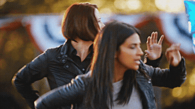 Two Women Are Dancing In Front Of A Banner That Says ' U.s. ' GIF