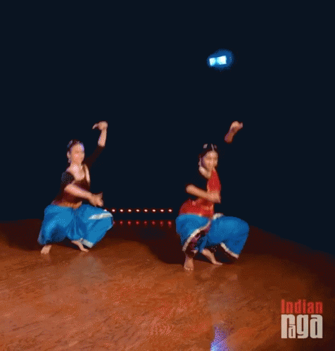 Two Women Are Dancing On A Stage With The Words Indian Goa Written On The Bottom GIF