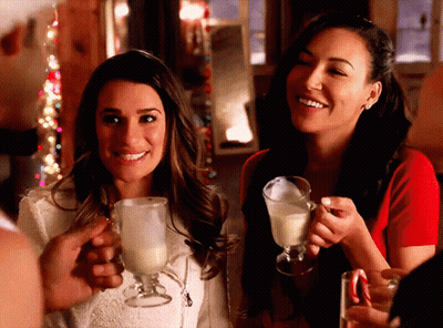 Two Women Are Holding Glasses Of Milk And Smiling At The Camera GIF