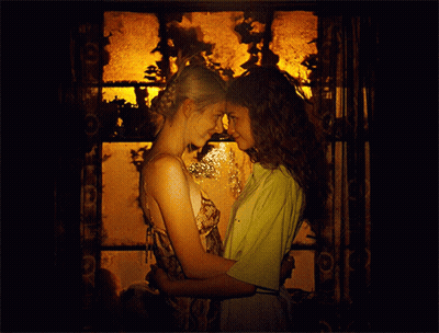Two Women Are Hugging And Looking At Each Other In A Dark Room GIF