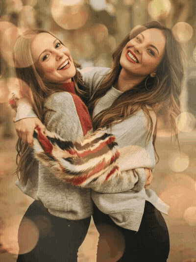 Two Women Are Hugging Each Other And Smiling For A Picture GIF