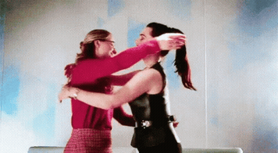 Two Women Are Hugging Each Other In A Room And One Of Them Is Holding The Other 'S Hair . GIF
