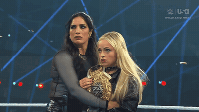 Two Women Are Hugging Each Other In A Wrestling Ring With The Words Riyadh Saudi Arabia On The Screen GIF