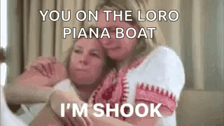 Two Women Are Hugging Each Other On A Bed And One Of Them Is Talking . GIF