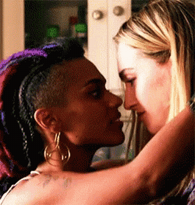 Two Women Are Kissing Each Other In A Kitchen . GIF