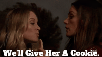 Two Women Are Kissing With The Words " We 'Ll Give Her A Cookie " On The Bottom GIF