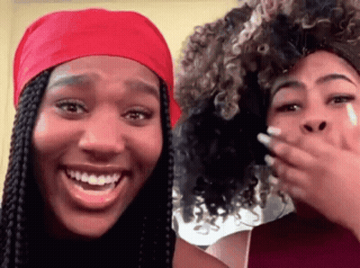 Two Women Are Laughing And One Has A Red Headband On GIF