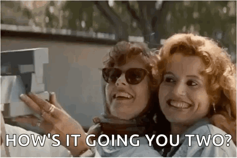 Two Women Are Laughing And Taking A Picture With A Camera . GIF